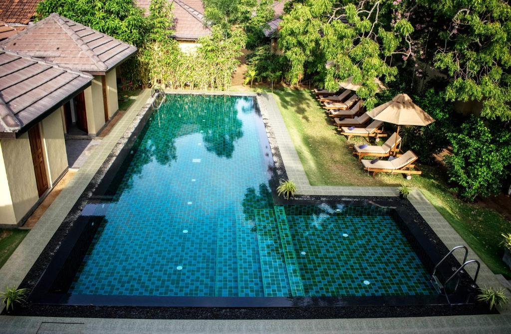 an overhead view of a swimming pool with chairs and an umbrella at The Spice Trail in Arugam Bay