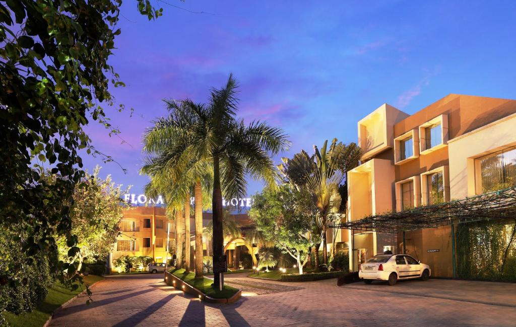 a street with palm trees and a building at Flora Airport Hotel and Convention Centre Kochi in Nedumbassery