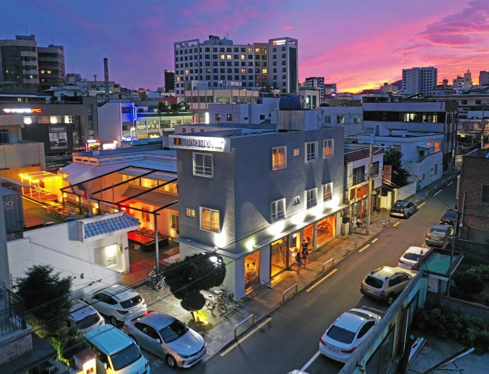 een skyline van de stad met auto's geparkeerd op een straat bij Mido Hostel in Seogwipo