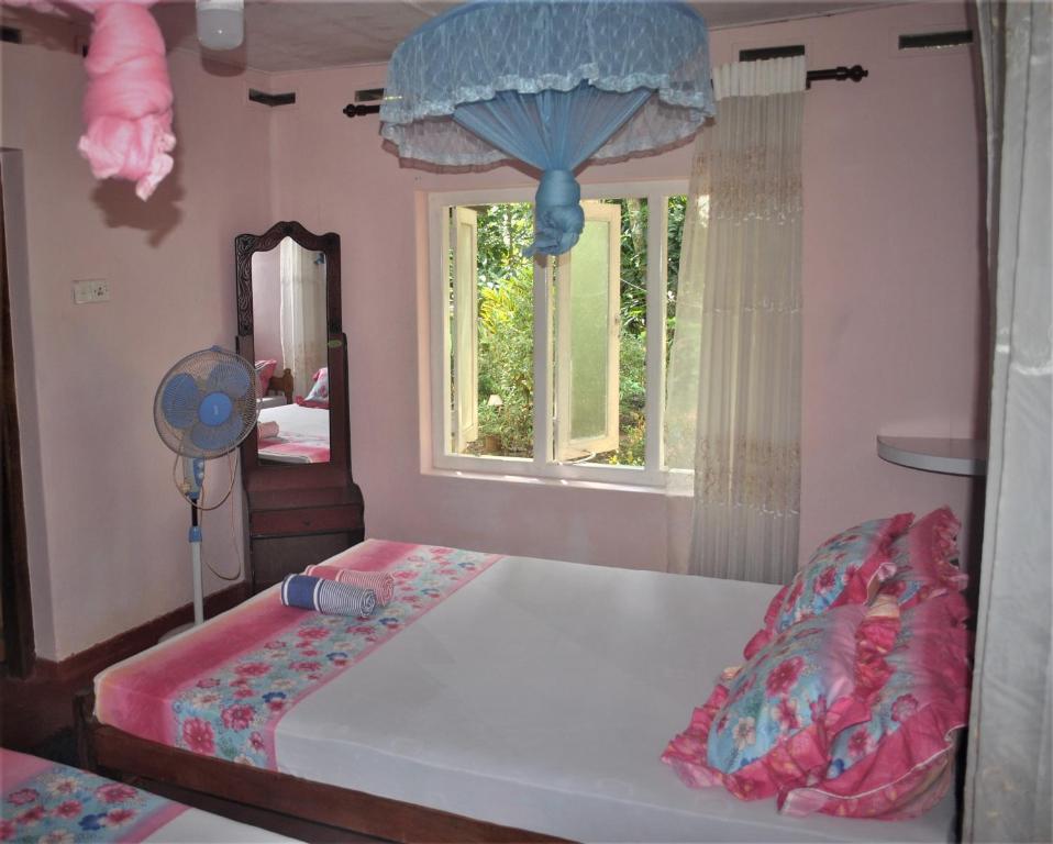 Deniyaya Guest House في دينيايا: غرفة نوم بسرير ومرآة ونافذة