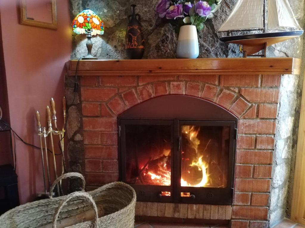 a brick fireplace with a fire in it at Casa Rural La Guapeta in Ademuz