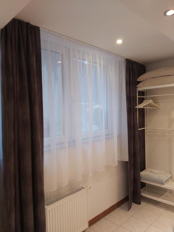 een raam met witte gordijnen in een kamer bij FeWo Marussia in Rust
