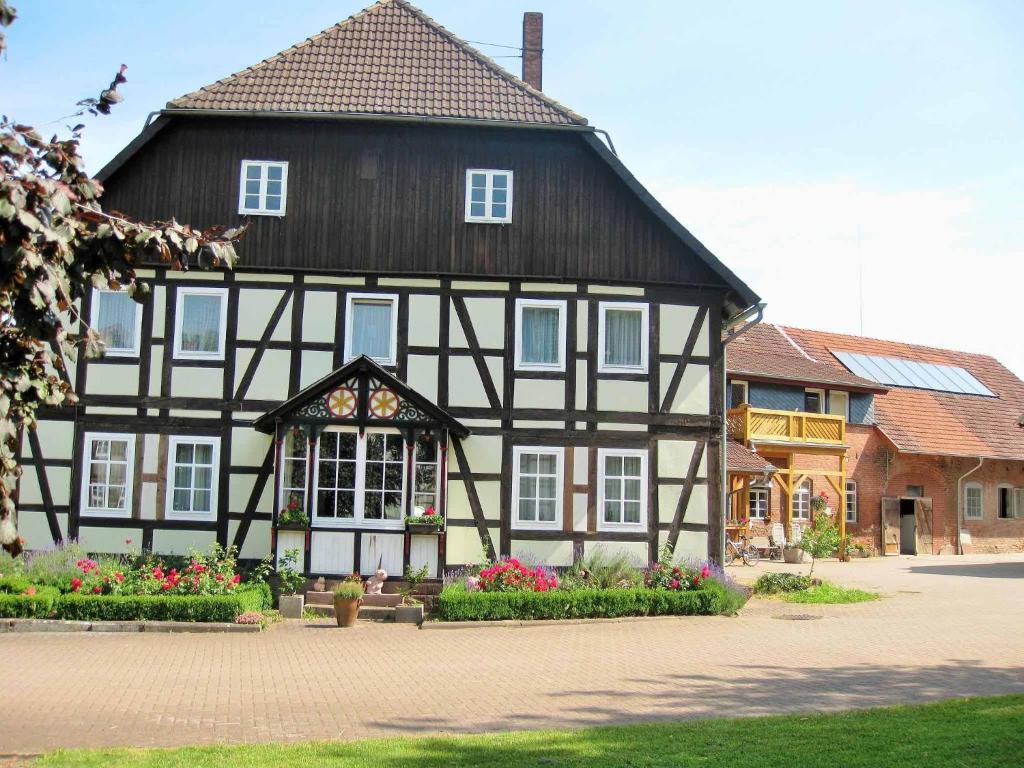 een zwart-wit gebouw met bloemen ervoor bij Müllers Hof Ferienwohnung/Pension in Emmerthal