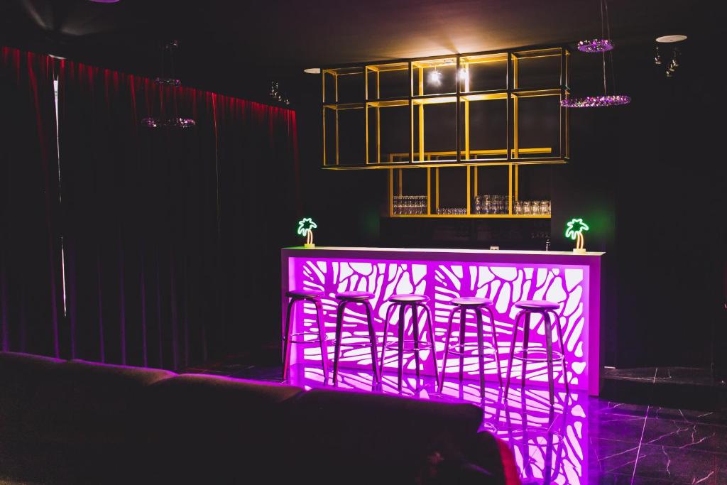 fioletowy bar z krzesłami w ciemni w obiekcie Holiday House Apartament 95m2 Deptak Bogusława w Szczecinie