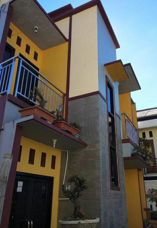 ein großes Haus mit Gelb und Blau in der Unterkunft Homestay Lingga Yoni DIENG in Banjarnegara