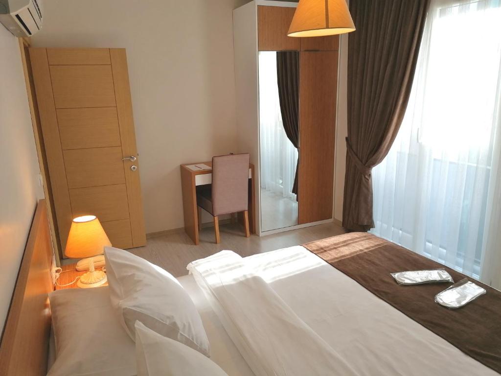 1 dormitorio con 1 cama, 1 silla y 1 ventana en Tuzla Hill Suites en Tuzla