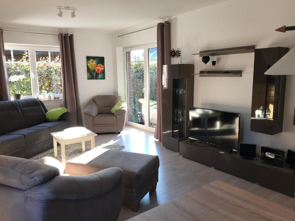a living room with a couch and a tv at Zuhause Woanders - Kuhtrade in Wildeshausen