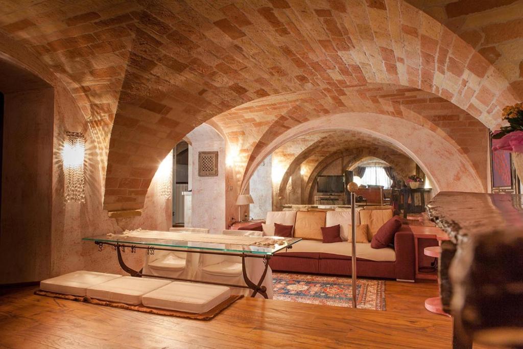 a living room with a couch and a table at MarcheAmore - Bottega di Giacomino for art lovers, with private courtyard in Fermo