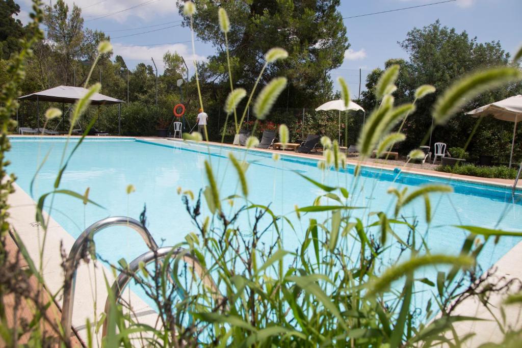 uma grande piscina azul com cadeiras e guarda-sóis em Inout em Barcelona