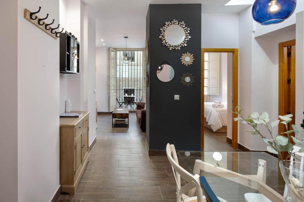 a dining room and living room with a glass table at Apartamento Mágico Carretería in Málaga