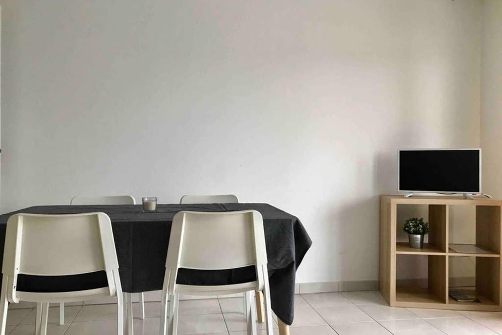 stół jadalny z krzesłami i telewizor w obiekcie Appartement Stella-Plage w mieście Cucq