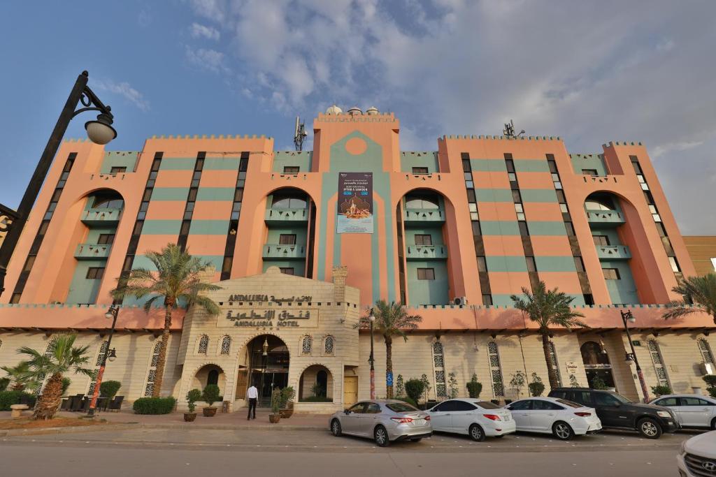 un gran edificio con coches estacionados frente a él en Mena Andalusia Riyadh, en Riad