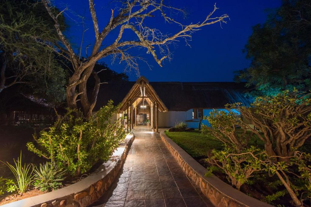 a house with a lit up front yard at night at Thornybush Jackalberry Lodge in Thornybush Game Reserve