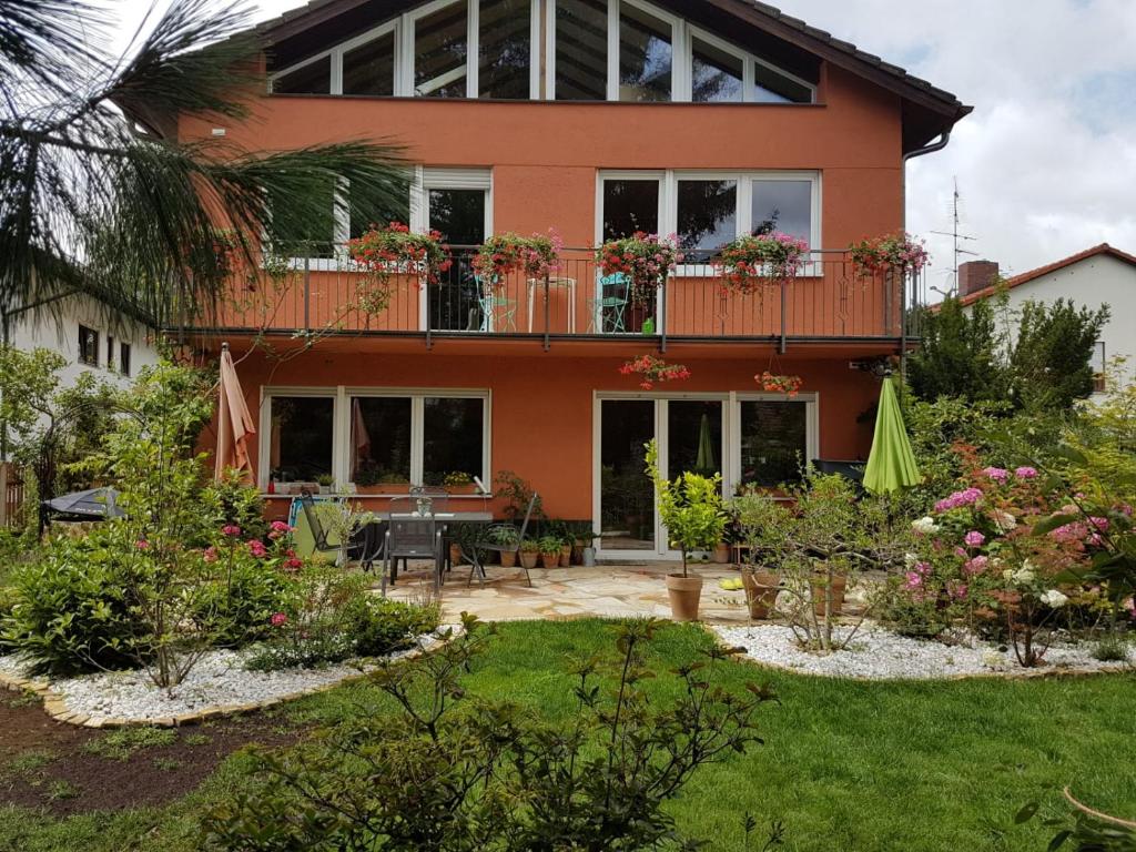 a house with a balcony and a garden at Südländische Flair in Neubiberg