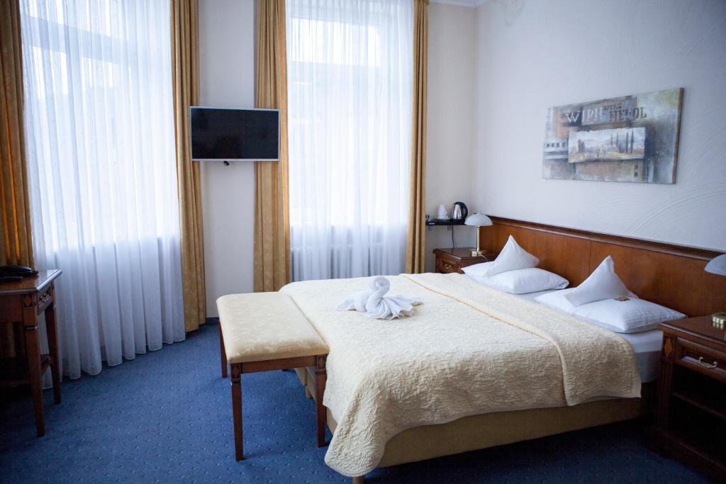 a hotel room with a bed and a flat screen tv at Hotel Baden in Bonn