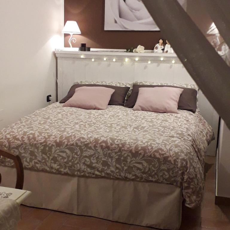 a bedroom with a bed with pink pillows at Lo scrigno di Simon in Senigallia