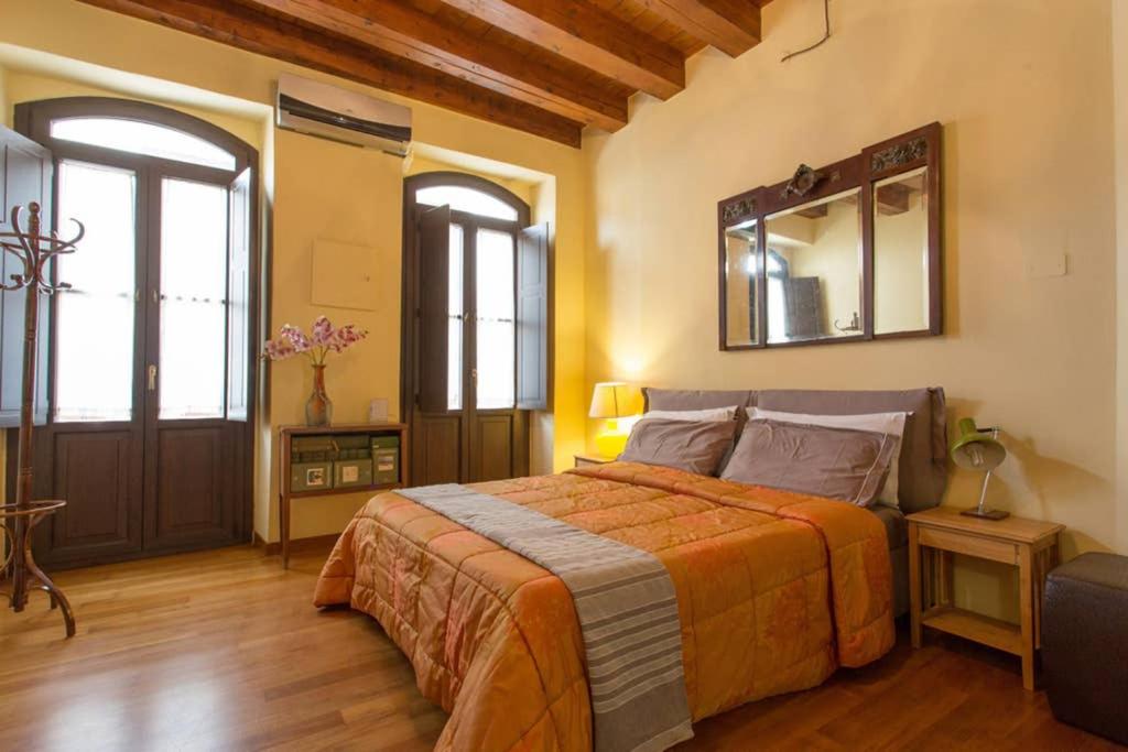 una camera da letto con un letto e uno specchio a parete di My Lovely Home a Cagliari