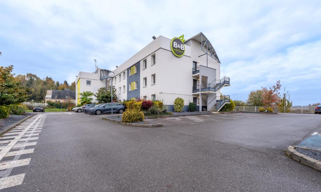 un gran edificio blanco con un reloj en él en B&B HOTEL Beauvais en Beauvais