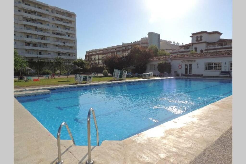 ein großer blauer Pool mit Gebäuden im Hintergrund in der Unterkunft Carihuela Palace Studio 418 Beach - Playa in Torremolinos