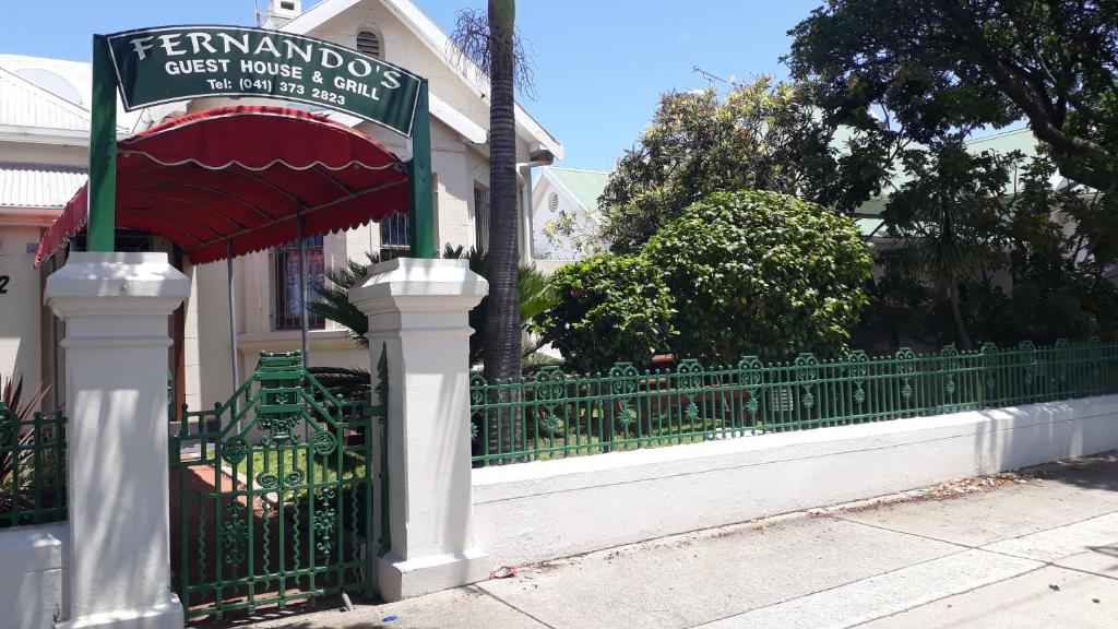 un portail vert avec un panneau devant une maison dans l'établissement Fernando's the Grange, à Port Elizabeth