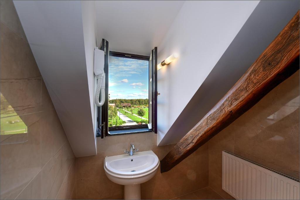 a bathroom with a toilet and a window at Hotel Dvorac Jurjevec in Lekenik