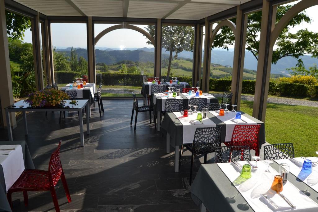 un restaurante con mesas y sillas y vistas en Relais Borgo del Gallo, en Acqui Terme
