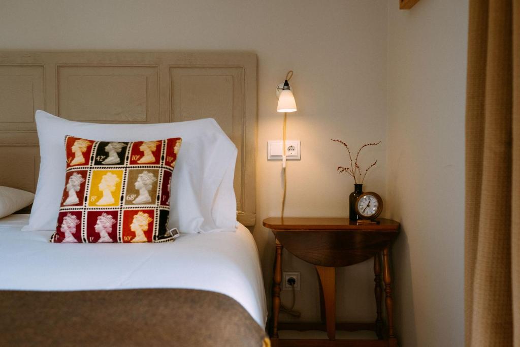 a bedroom with a bed and a table with a clock at el gran sueño Boutique Hotel & Apartamentos - Adults Only in Pintueles