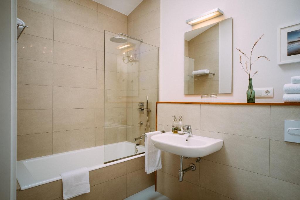 a bathroom with a sink and a shower and a tub at el gran sueño Boutique Hotel & Apartamentos - Adults Only in Pintueles