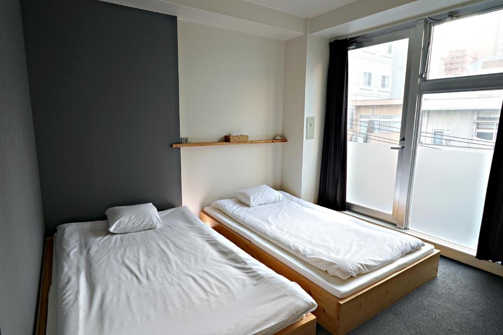 Santiago Guesthouse Hiroshima tesisinde bir odada yatak veya yataklar