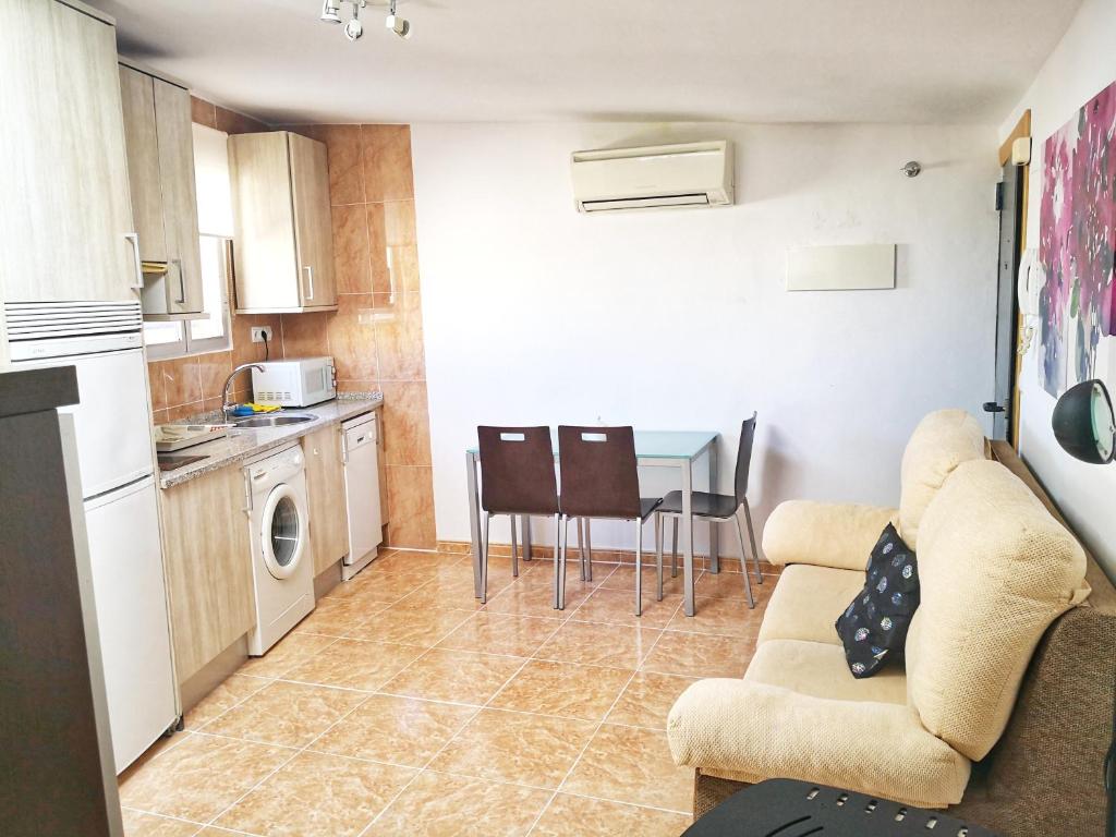 eine Küche und ein Wohnzimmer mit einem Sofa und einem Tisch in der Unterkunft Apartamento Coco 567 in Avila