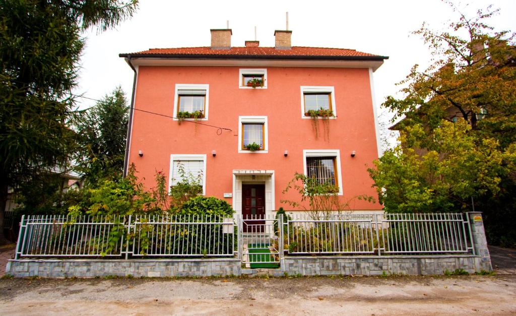 une maison avec une clôture devant elle dans l'établissement Guest House Pikapolonca, à Maribor