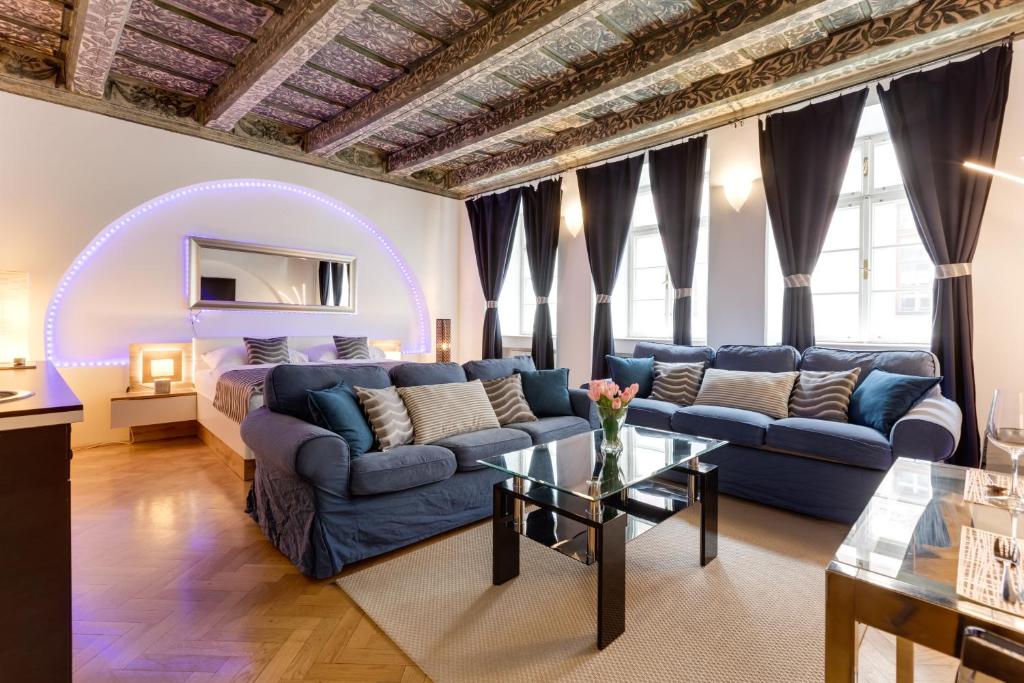 ein Wohnzimmer mit einem Sofa und einem Tisch in der Unterkunft Charles Bridge Royal Apartment - Castle District in Prag