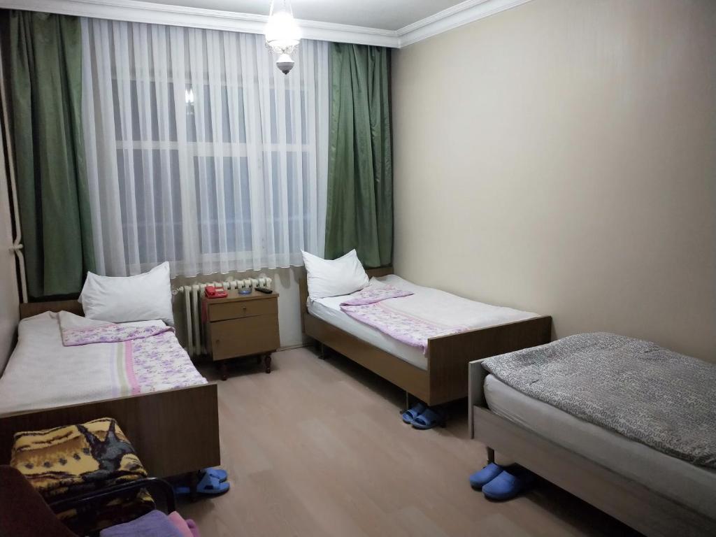 エルズルムにあるOTEL ÇINARのベッド2台と窓が備わる小さな客室です。