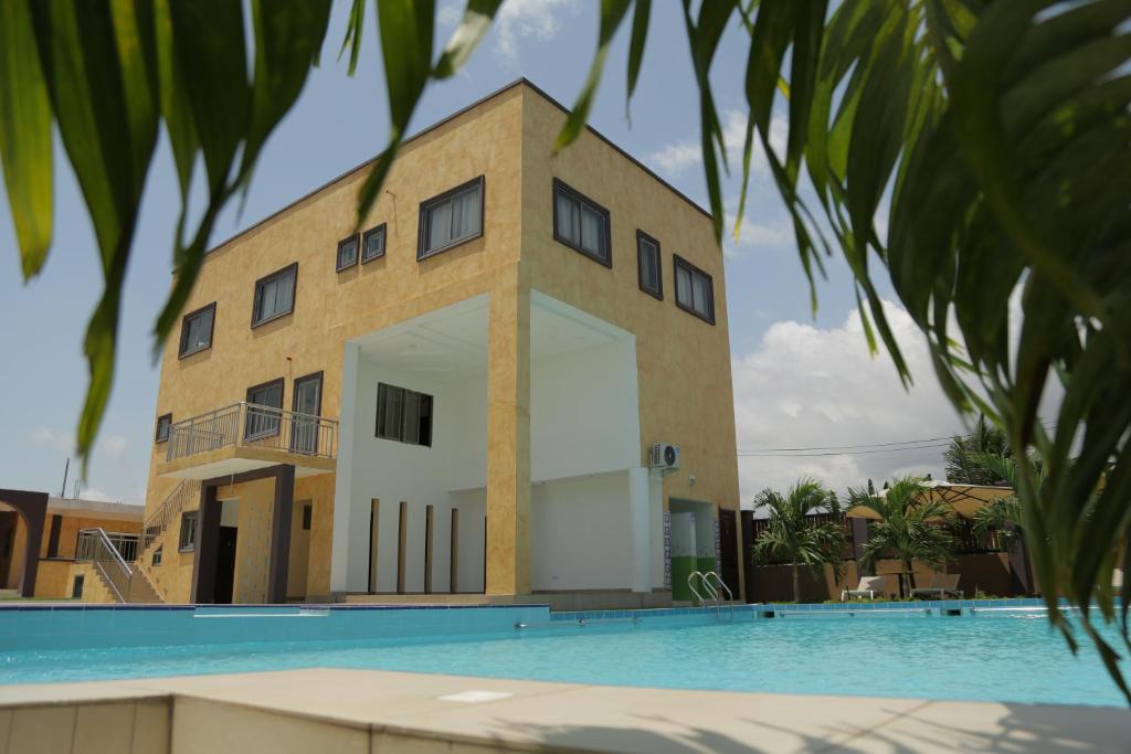 a building with a swimming pool in front of it at Cocktail and Dreams Hotel in Accra