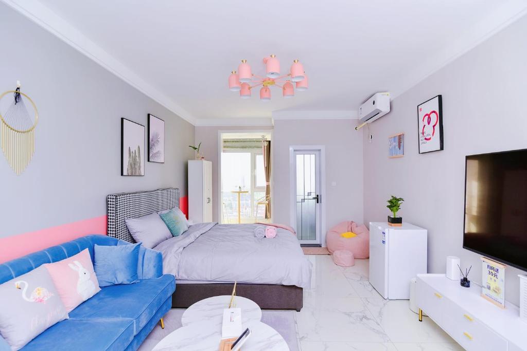 a living room with a blue couch and a bed at Luoyang Luolong·Dazhao International Plaza in Luoyang