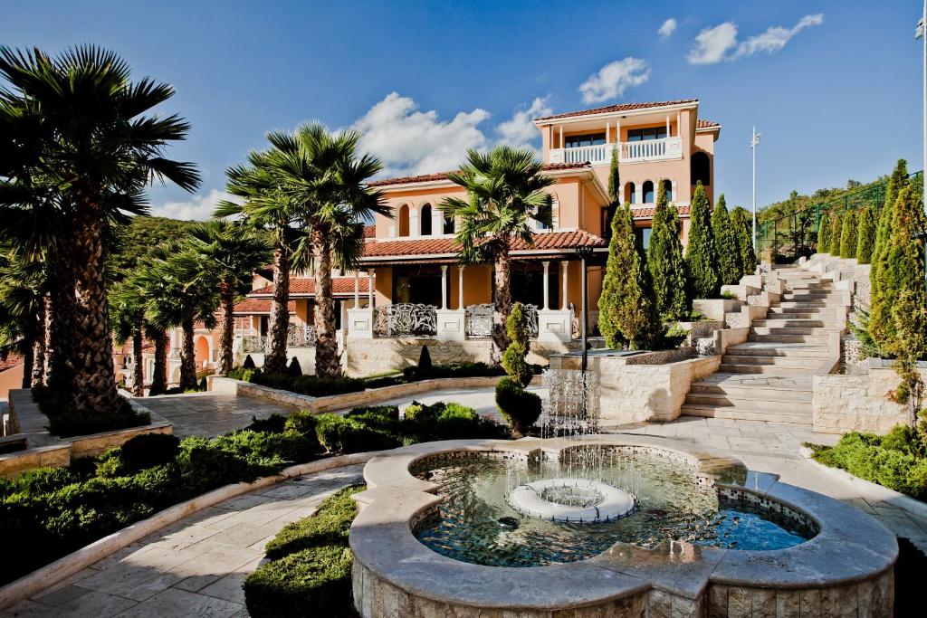 a house with a fountain in the middle of a garden at Villas Elenite Premium in Elenite