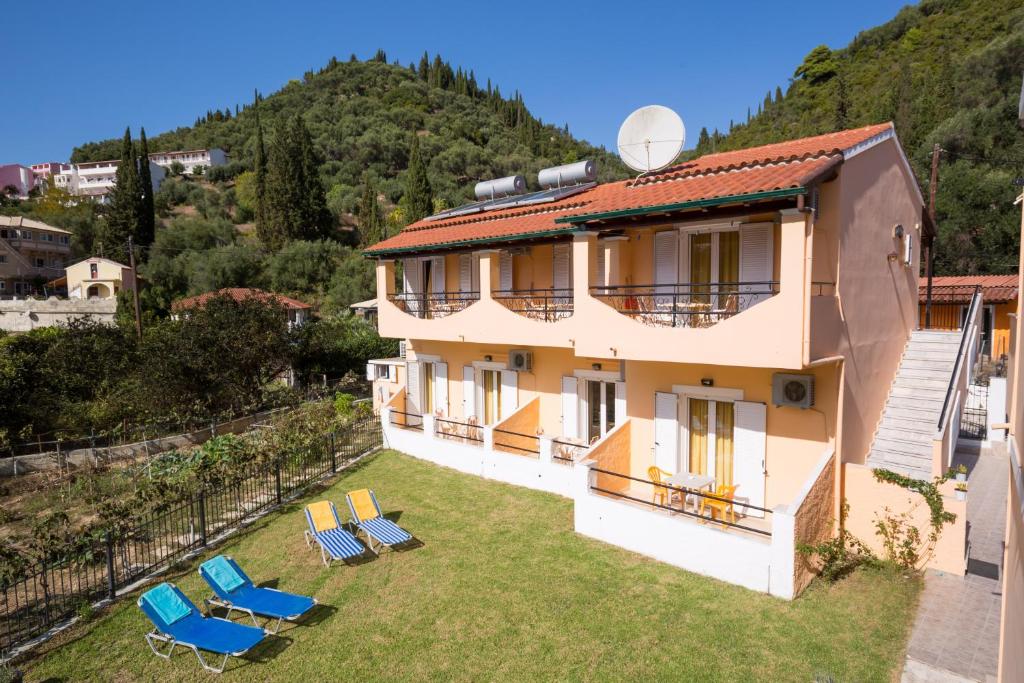 una casa con sillas en un patio con una montaña en Odysseus Apartments By Hotelius, en Agios Gordios