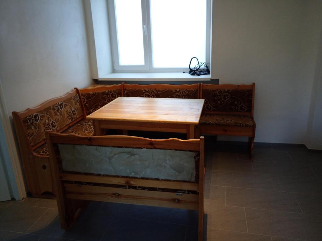 a table and a bench in a room with a window at Penzion Ostrov u Stribra 13 in Kostelec