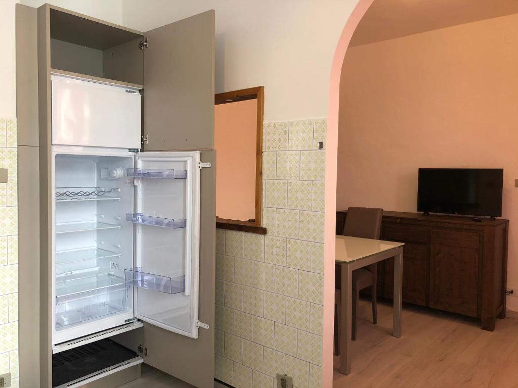 een lege koelkast in een kamer met een tafel bij Casa Vauterin VDA CIR 0019- 0021-0022-0026- in La Thuile