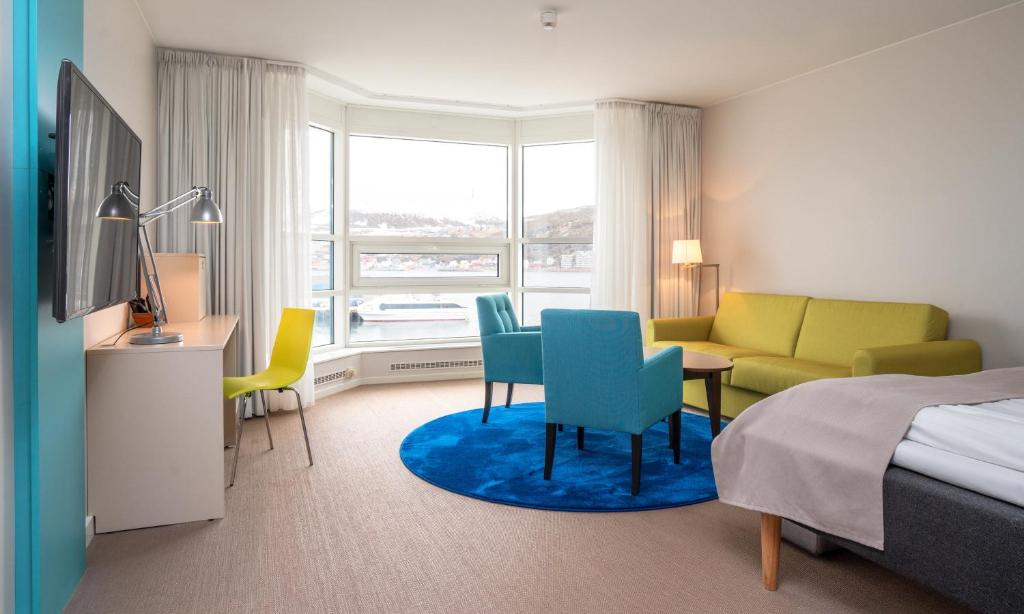 ein Hotelzimmer mit einem Bett, einem Schreibtisch und Stühlen in der Unterkunft Thon Hotel Hammerfest in Hammerfest
