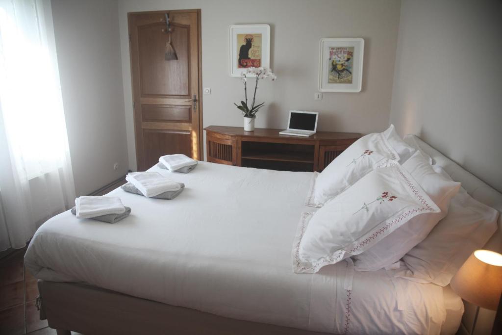 a bedroom with a bed with white sheets and pillows at La Maison De Maria in Folembray