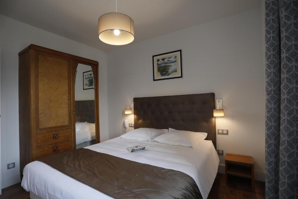 1 dormitorio con 1 cama grande y cabecero de madera en RESIDENCE LE SPLENDID, en Villard-de-Lans
