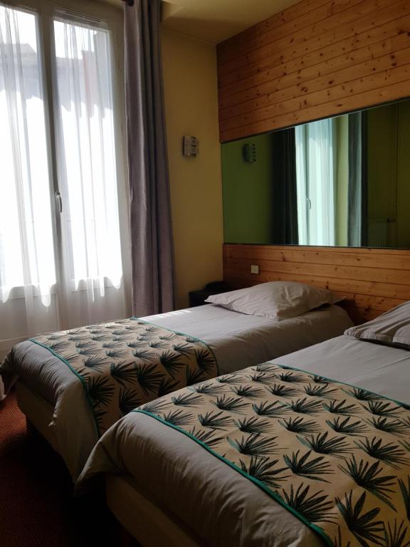 Cette chambre comprend 2 lits et une fenêtre. dans l'établissement Dyke Hotel, au Puy-en-Velay
