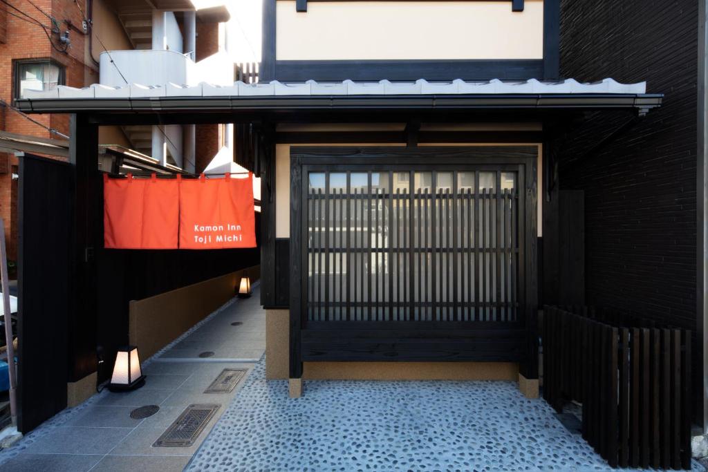 un accès à un bâtiment avec une porte noire dans l'établissement カモンイン 東寺道, à Kyoto