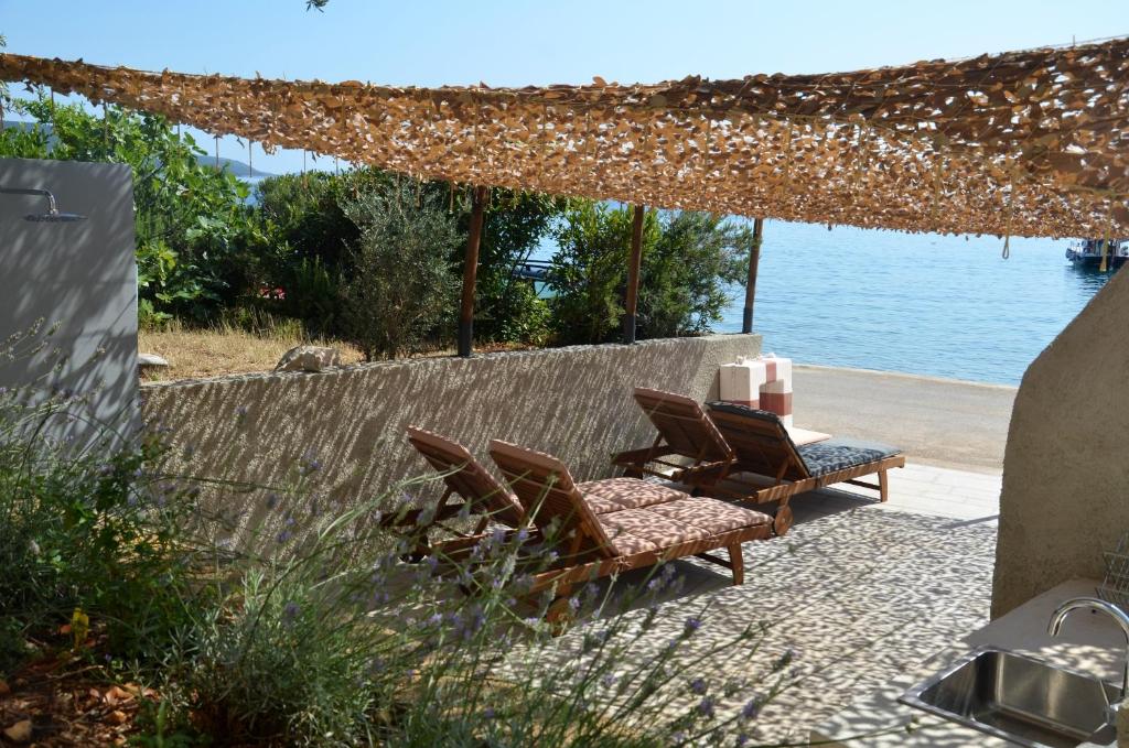 a group of chairs sitting on a patio next to the water at Apartments MartaMare in Martinšćica