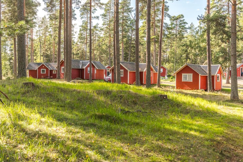 una fila de cabañas rojas en un bosque en First Camp Duse Udde - Säffle, en Säffle