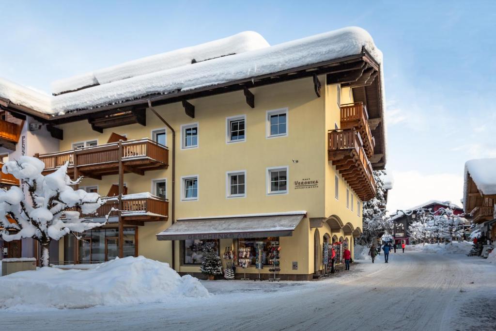 a building with snow on top of it on a street at Haus Veronika - Appartements by Miha in Westendorf