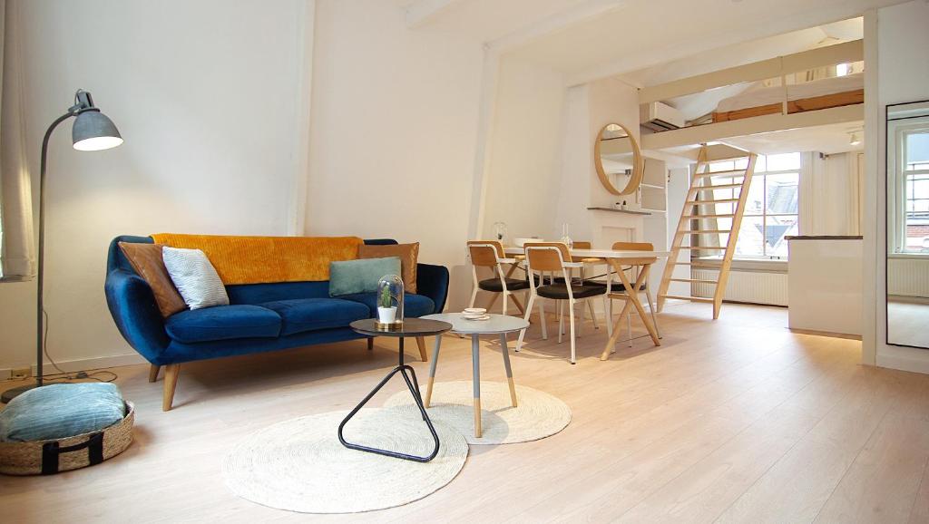 een woonkamer met een blauwe bank en een tafel bij Loft Leidsegracht in Amsterdam