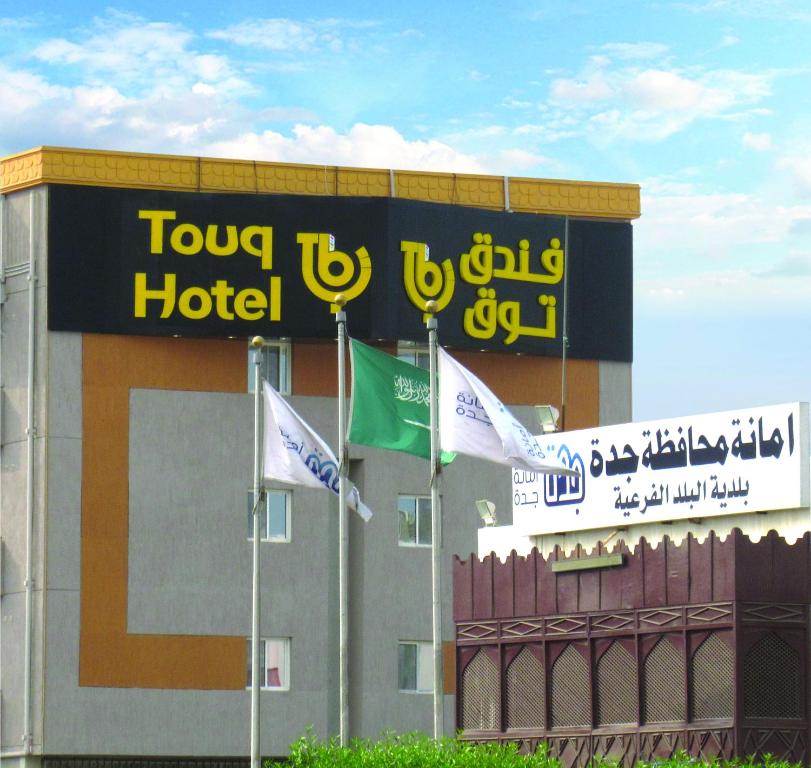 a hotel with flags in front of a building at Touq Balad in Jeddah