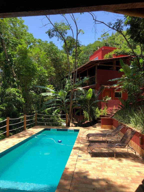 a swimming pool in front of a house at Casa Rossa Bungalows & Apartments in Morro de São Paulo